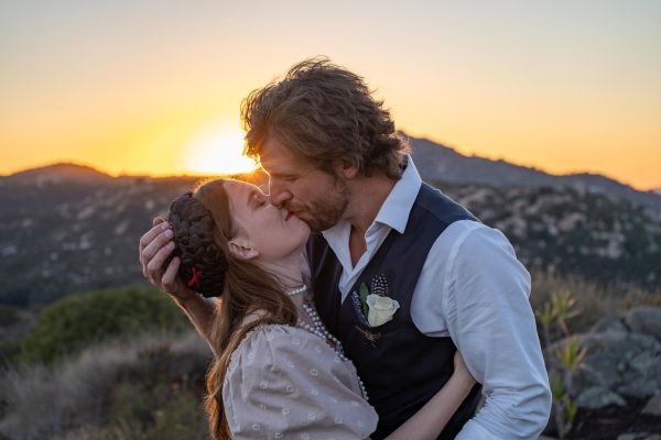 Eve and Leif kissing in the sunset overlooking the Ramona California grasslands and mountains